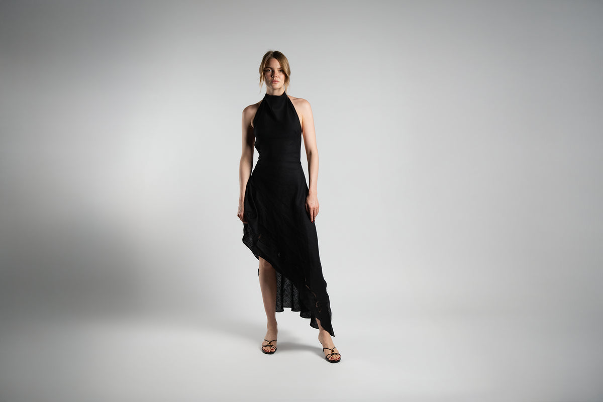 ALISADUDAJ black linen halter dress and trouser set, front view showing asymmetric slit-detail hem in movement, linen