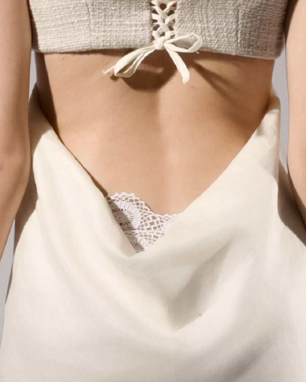 ALISADUDAJ ivory linen empire-waist gown, back close-up of bodice tie and crochet lace trim, linen