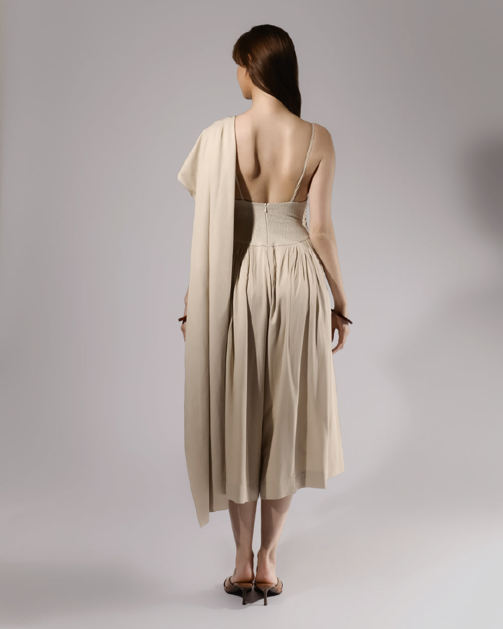 ALISADUDAJ beige linen and viscose one-shoulder draped dress, back view showing open back, zip and textured waist panel
