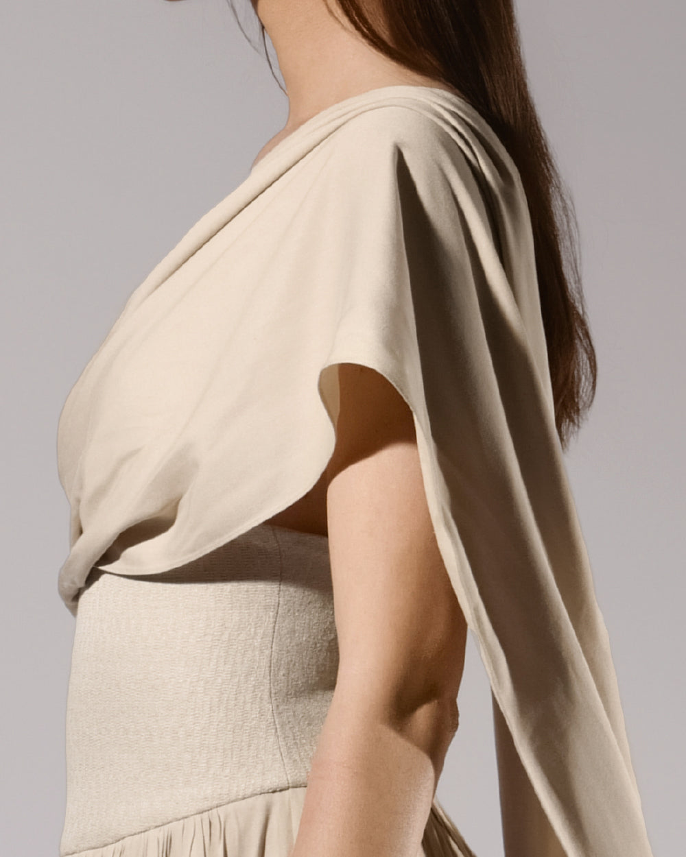 ALISADUDAJ beige linen and viscose one-shoulder draped dress, side close-up of draped sleeve and waist seam, linen and viscose