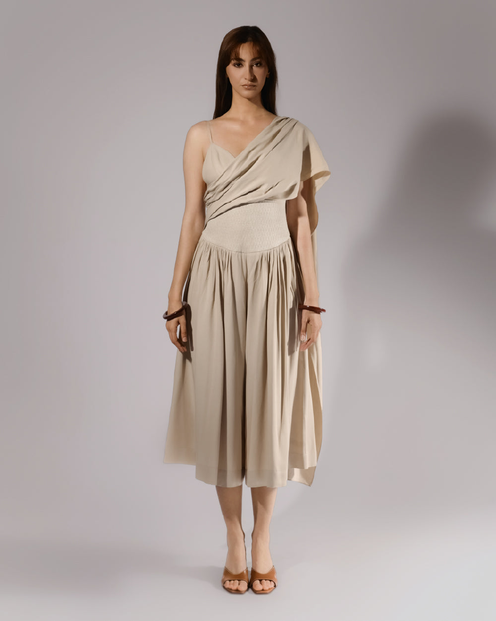ALISADUDAJ beige linen and viscose one-shoulder draped dress, front view, full length, showing draped sash and gathered culotte skirt