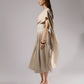 ALISADUDAJ beige linen and viscose one-shoulder draped dress, side profile showing trailing drape panel