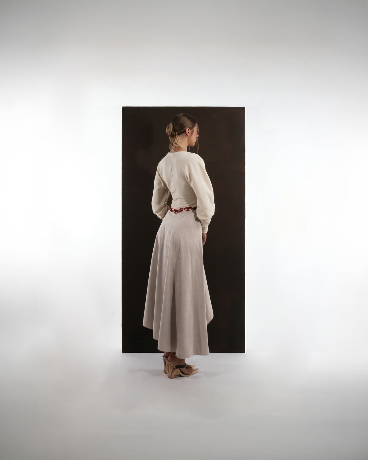 ALISADUDAJ beige wool asymmetric dress, back view showing high-low hem and full sleeves