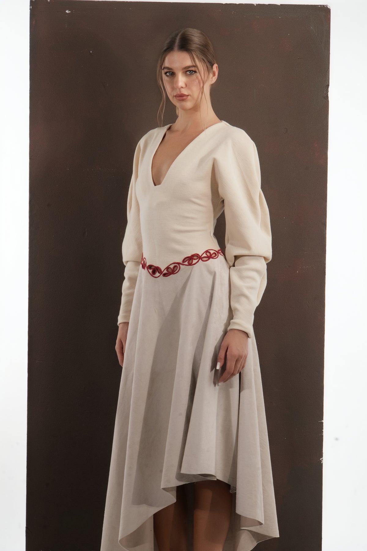 ALISADUDAJ beige wool asymmetric dress, front close-up of red scroll embroidery at the waist, wool