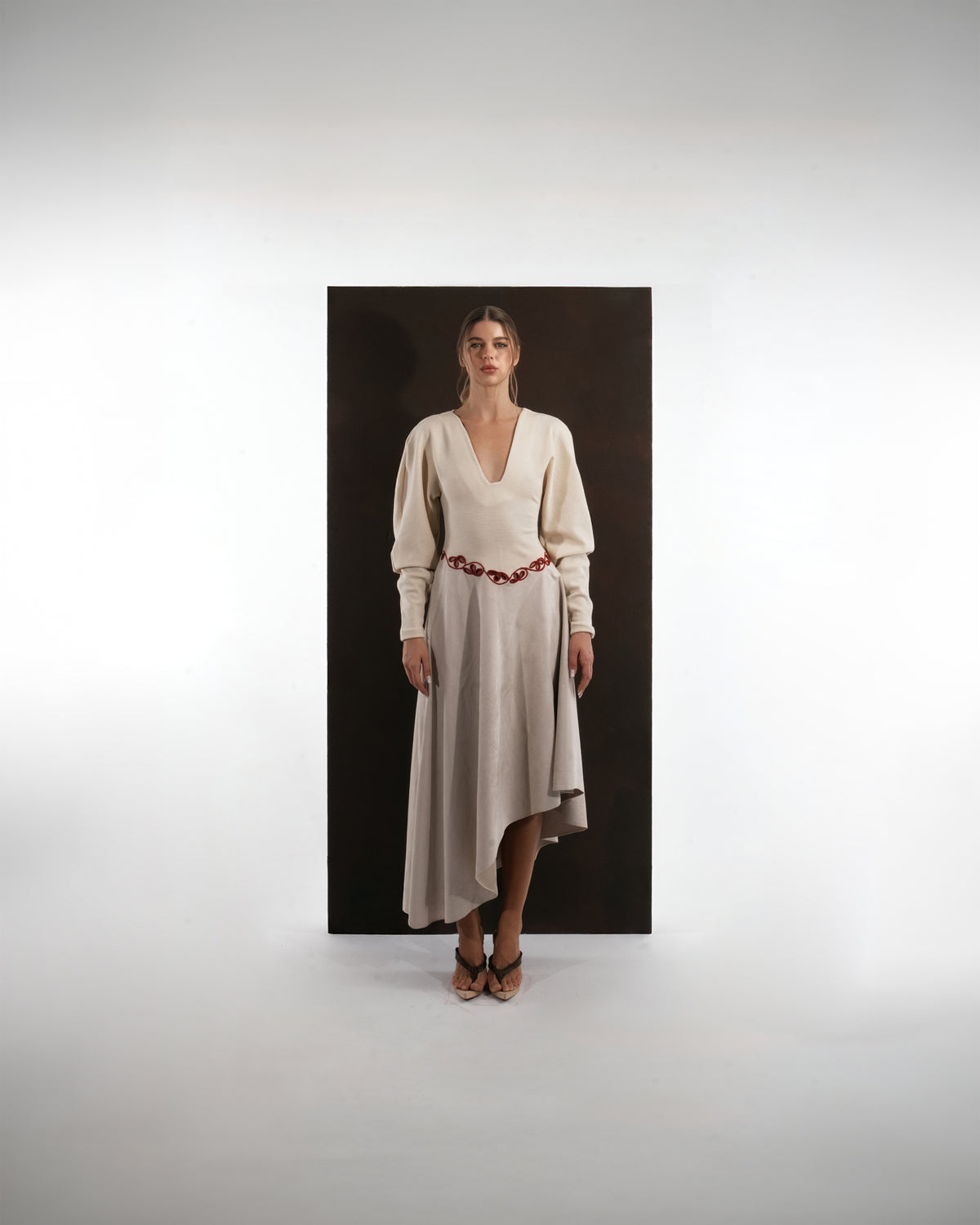 ALISADUDAJ beige wool asymmetric dress, front three-quarter view showing deep V neckline
