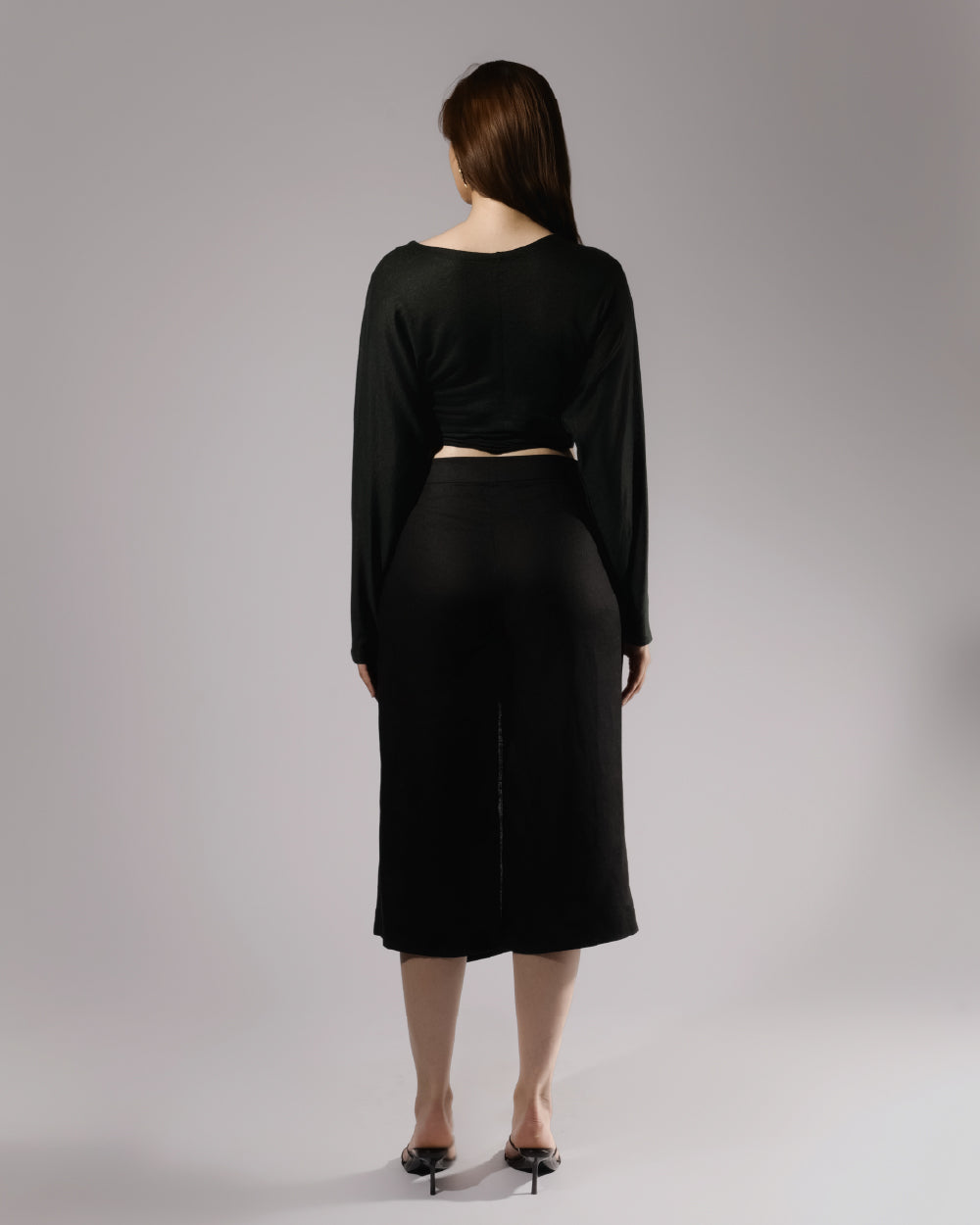 ALISADUDAJ black linen deep-V wrap top and midi skirt set, back view showing cropped top and straight skirt with back slit