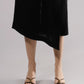 ALISADUDAJ black linen deep-V wrap top and midi skirt set, close-up of asymmetric skirt hem and strappy sandals
