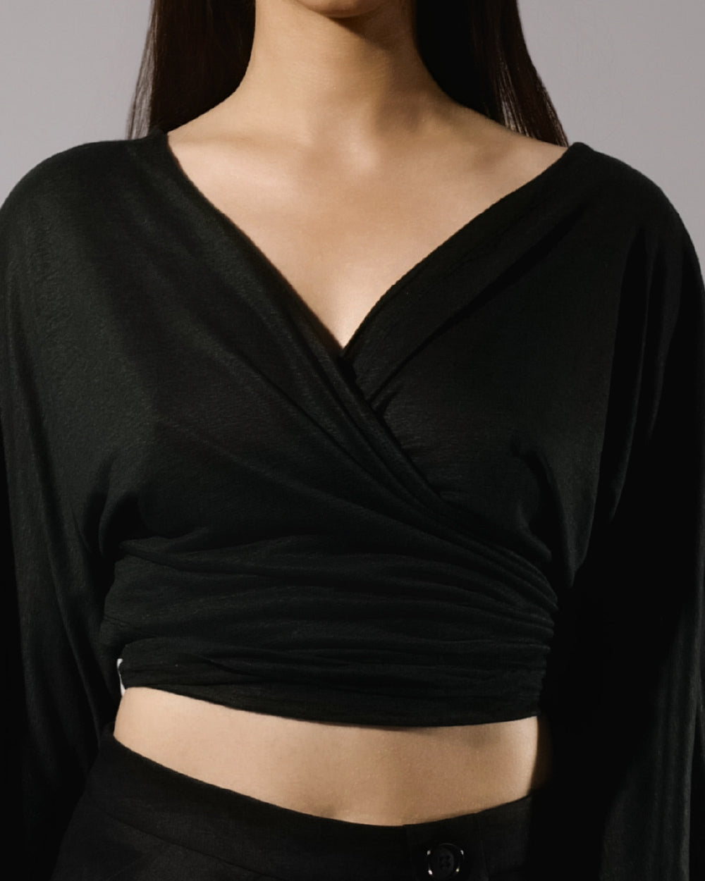 ALISADUDAJ black linen deep-V wrap top and midi skirt set, front close-up of crossover V neckline and tie-front wrap, linen