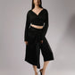 ALISADUDAJ black linen deep-V wrap top and midi skirt set, front three-quarter view showing crossover neckline and buttoned wrap waist
