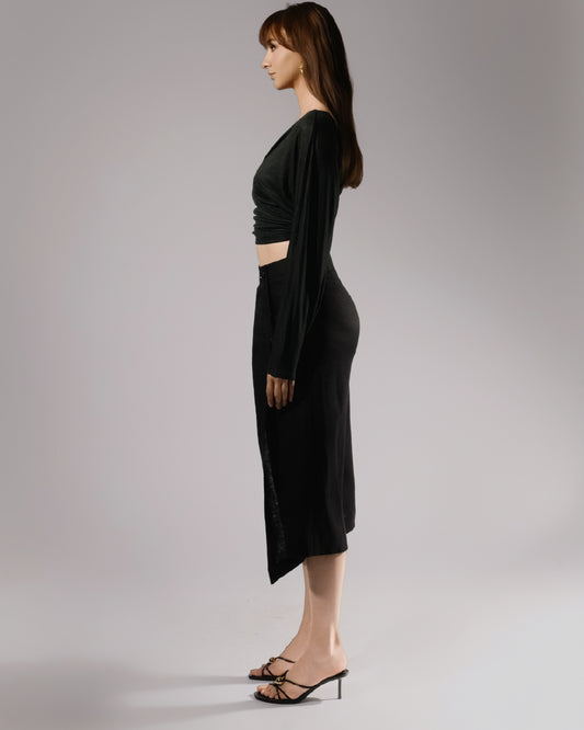 ALISADUDAJ black linen deep-V wrap top and midi skirt set, side profile showing draped sleeve and side slit