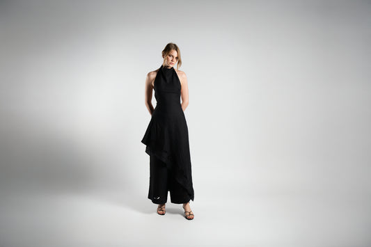 ALISADUDAJ black linen halter dress and trouser set, front three-quarter view showing draped halter neck and slit overlay