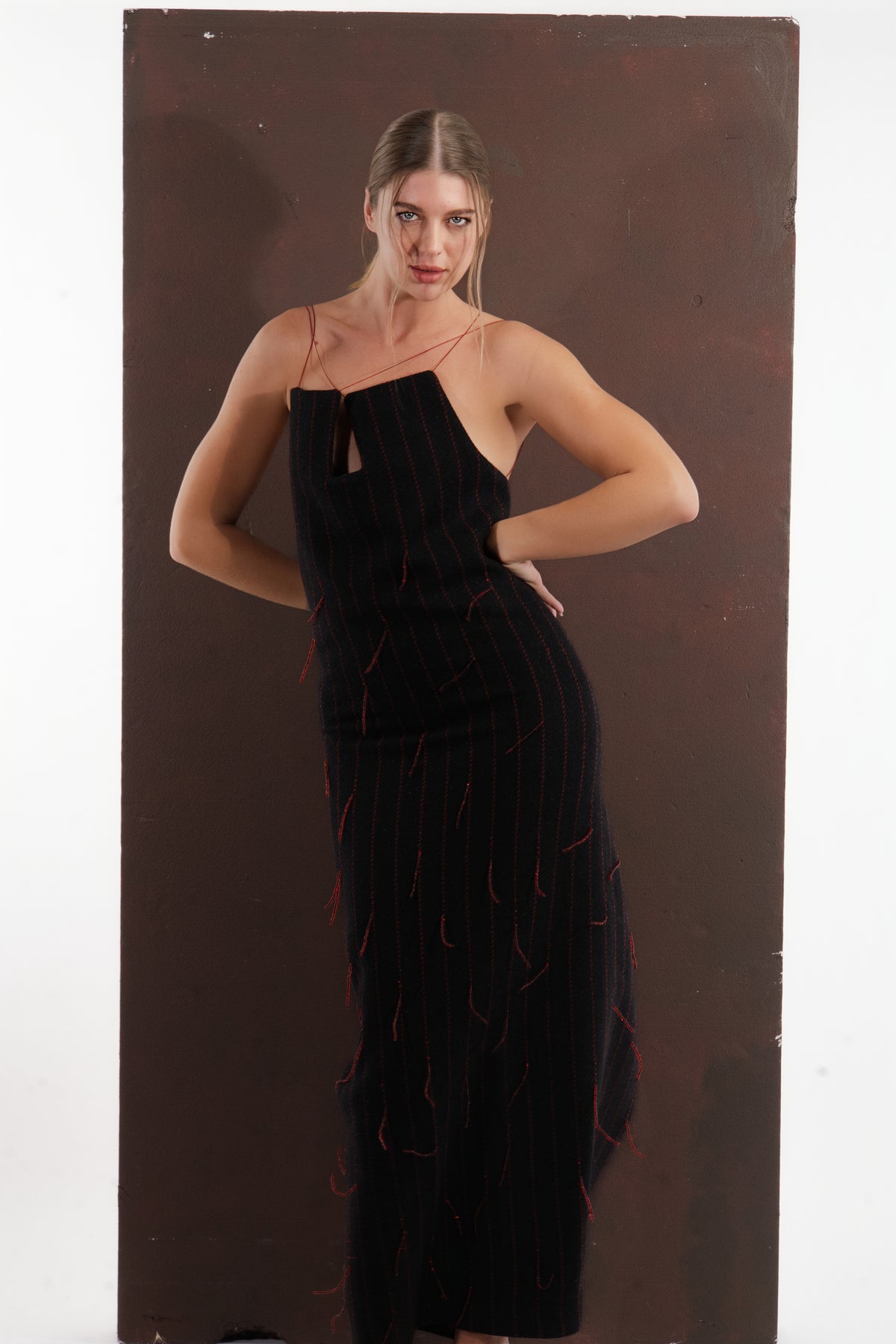 ALISADUDAJ black and red pinstripe wool maxi dress, three-quarter view with hand behind back showing fitted hip