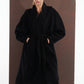 ALISADUDAJ black wool belted wrap coat, three-quarter view with hands in pockets showing coat drape