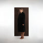 ALISADUDAJ black wool belted wrap coat, side three-quarter view showing wrap front and tie belt