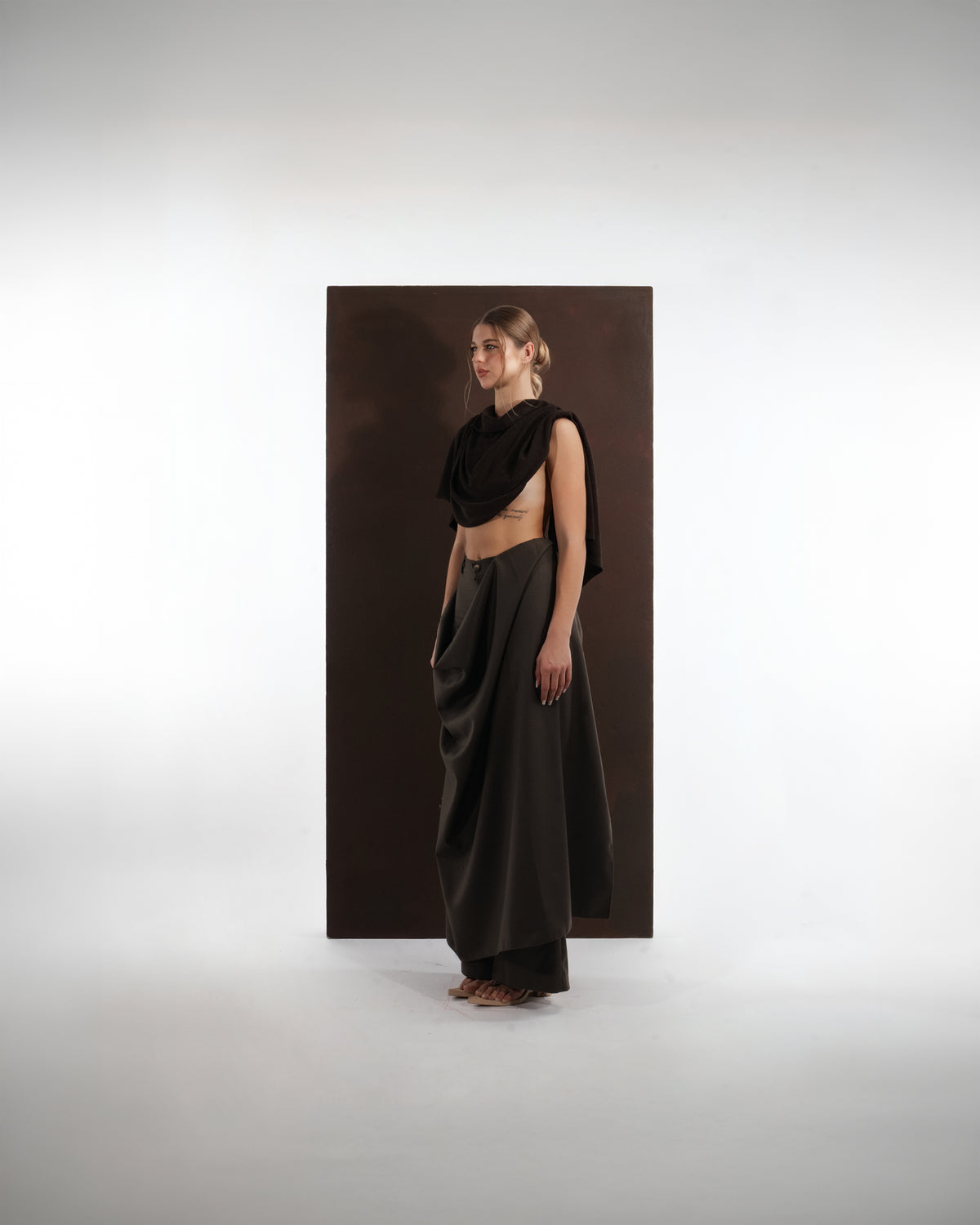 ALISADUDAJ black wool draped cowl top and trouser set, side three-quarter view showing draped hip panel