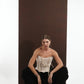 ALISADUDAJ black wool draped harem trousers, crouching front view with ivory corset top