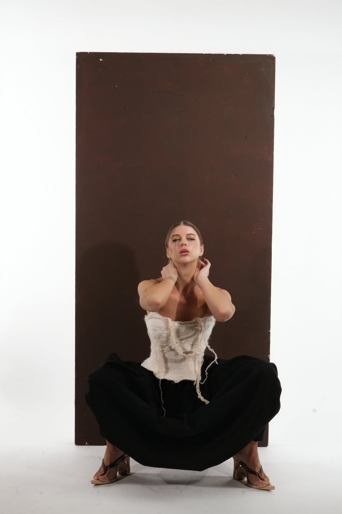ALISADUDAJ black wool draped harem trousers, crouching view showing spread drape and corset top