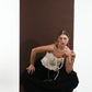 ALISADUDAJ black wool draped harem trousers, three-quarter crouching view showing fabric volume