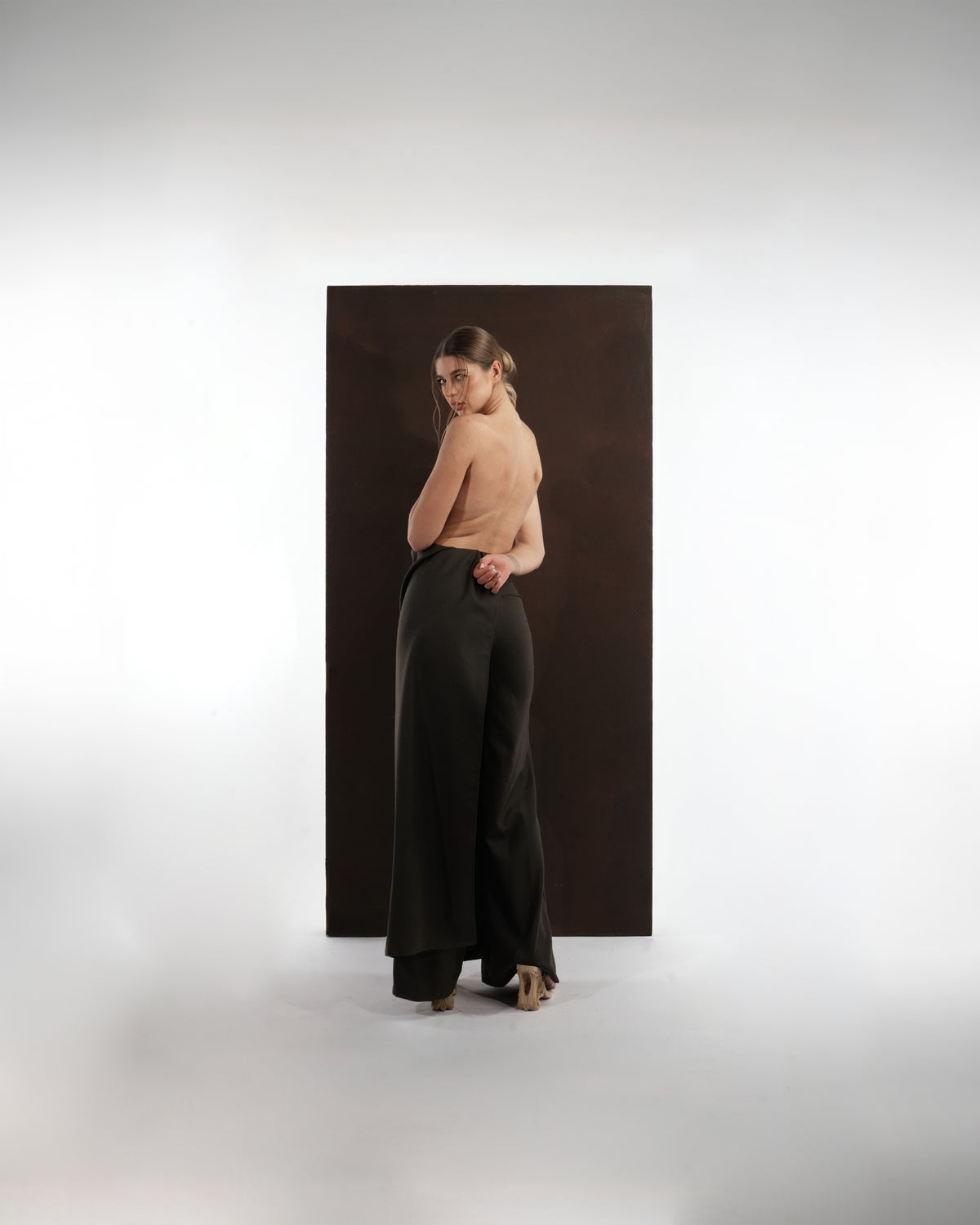 ALISADUDAJ black wool draped wide-leg trousers, back three-quarter view showing draped side panel, wool blend