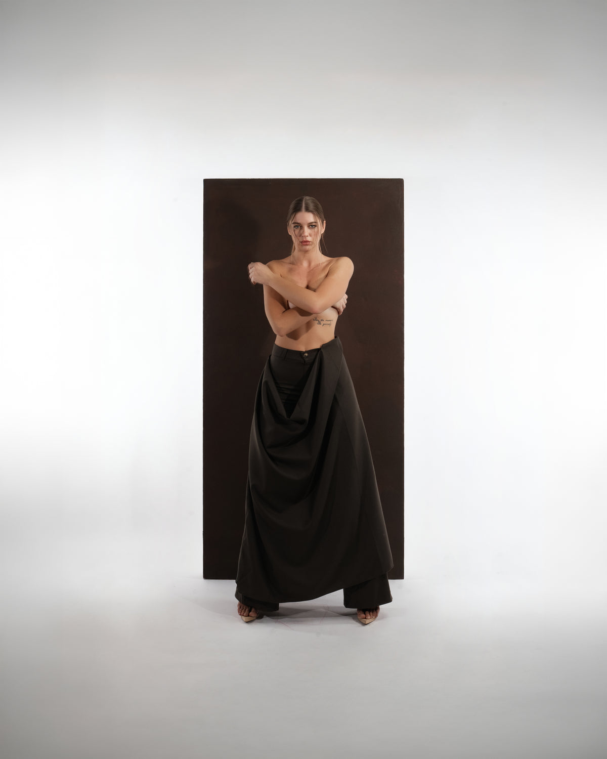 ALISADUDAJ black wool draped wide-leg trousers, front view showing button waistband and deep fabric folds