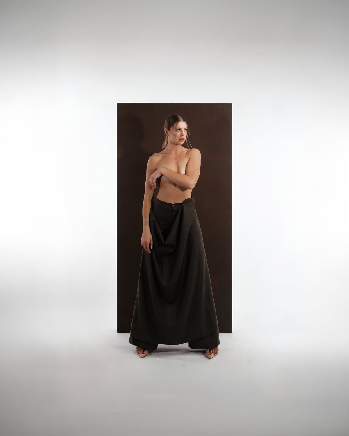 ALISADUDAJ black wool draped wide-leg trousers, three-quarter view showing draped overlay and wide leg