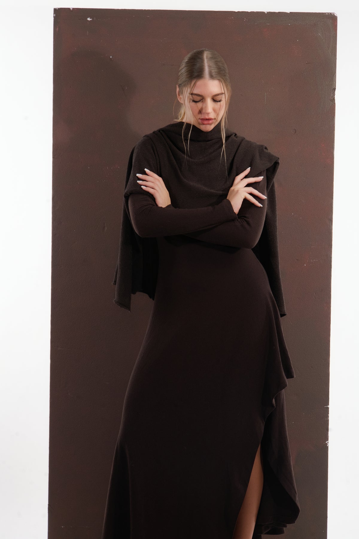 ALISADUDAJ brown wool open-back maxi dress, front view with shawl, arms crossed, looking down