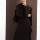 ALISADUDAJ brown wool open-back maxi dress, front view with draped shawl and hand at chin