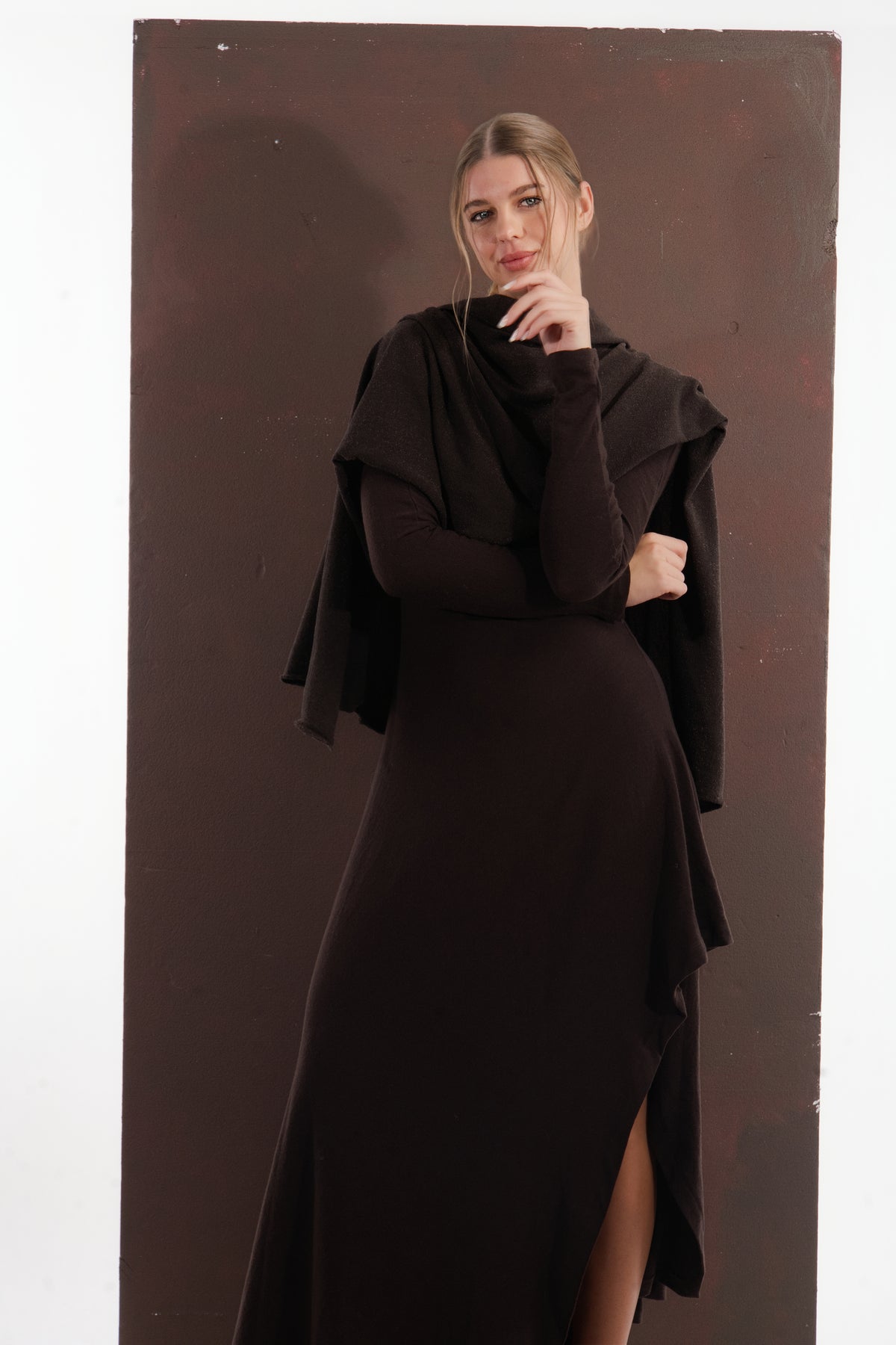 ALISADUDAJ brown wool open-back maxi dress, front view with draped shawl and hand at chin