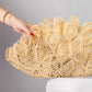 ALISADUDAJ Çantro beige crochet-lace clutch bag in polyester resin, close-up held by hand on a white stand, showing scalloped open-work edge