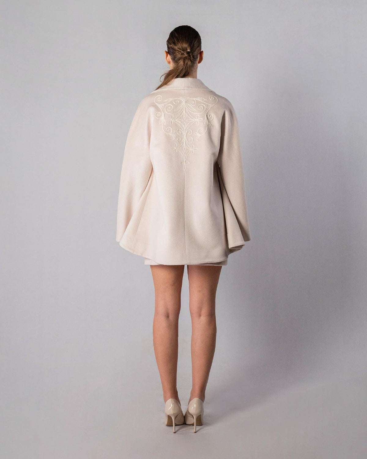 ALISADUDAJ CRAFT 01 beige cashmere coat and mini skirt set, back view showing scroll embroidery across the shoulders