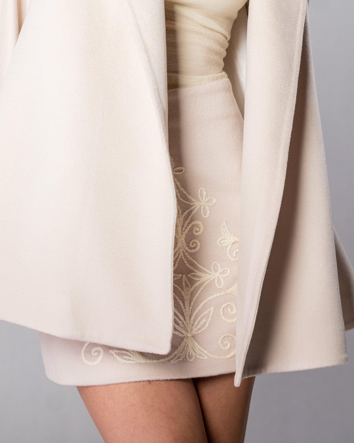 ALISADUDAJ CRAFT 01 beige cashmere mini skirt, close-up of tone-on-tone floral embroidery at the hip