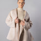 ALISADUDAJ CRAFT 01 beige cashmere coat and embroidered mini skirt set, front view holding coat open showing shawl collar