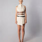 ALISADUDAJ CRAFT 03 white wool sleeveless funnel-neck mini dress with three leather belts, front view, full length, showing asymmetric wrap hem