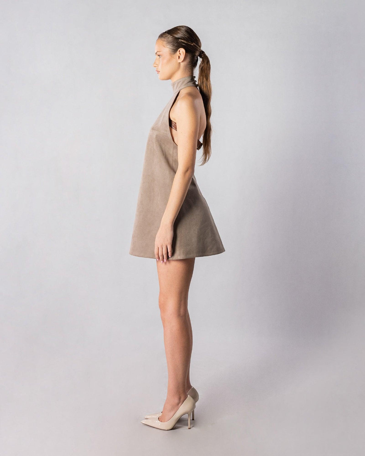 ALISADUDAJ CRAFT 06 grey faux-suede halter mini dress, side profile showing open side and leather back belt