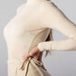 ALISADUDAJ CRAFT 07 off-white wool set, close-up of skirt waist tie bow against the fine-knit turtleneck