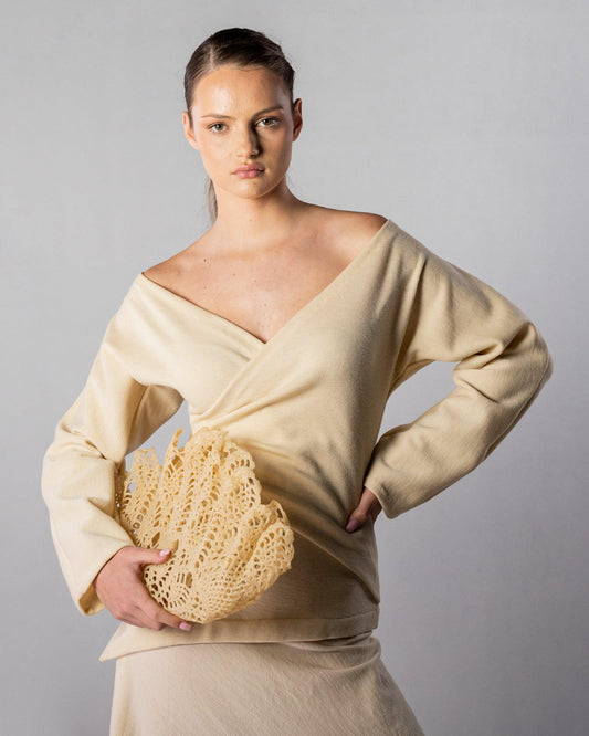 ALISADUDAJ CRAFT 08 off-white wool off-shoulder wrap top, half-length front view styled with the Çantro crochet clutch