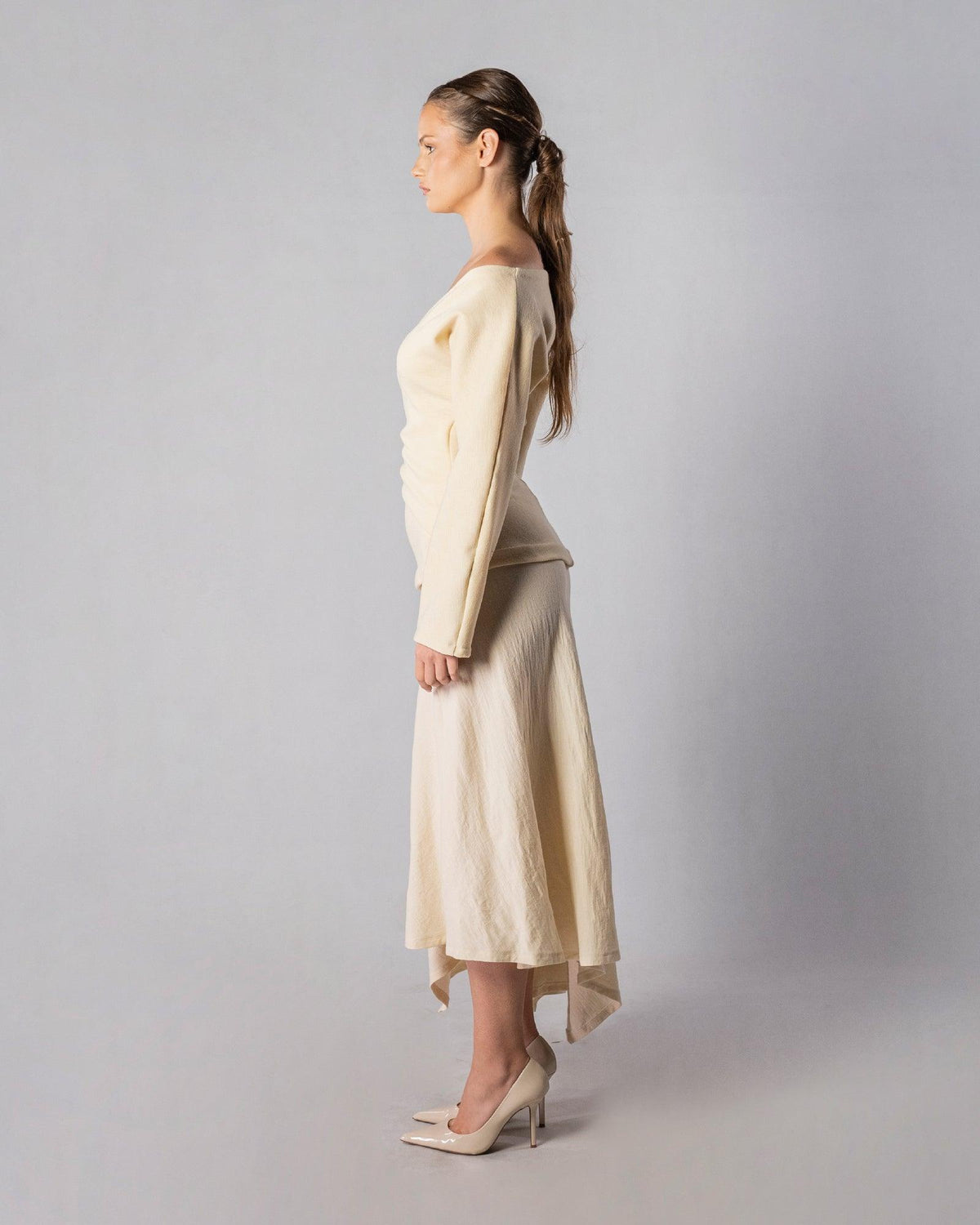 ALISADUDAJ CRAFT 08 off-white wool wrap top and midi skirt set, side profile showing long sleeves and asymmetric hem