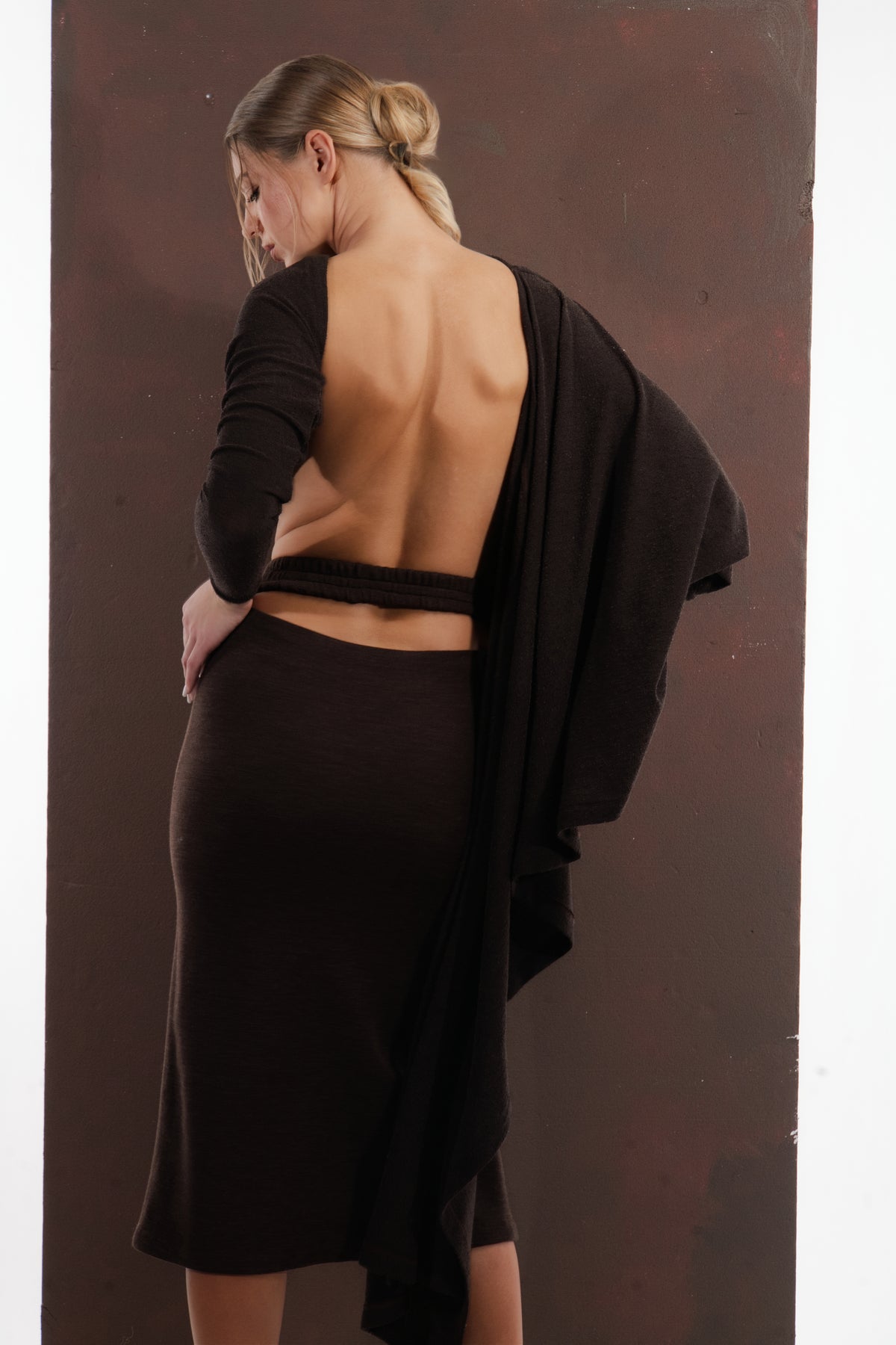ALISADUDAJ dark brown wool draped set, back view showing open back strap and drape over the skirt, wool blend