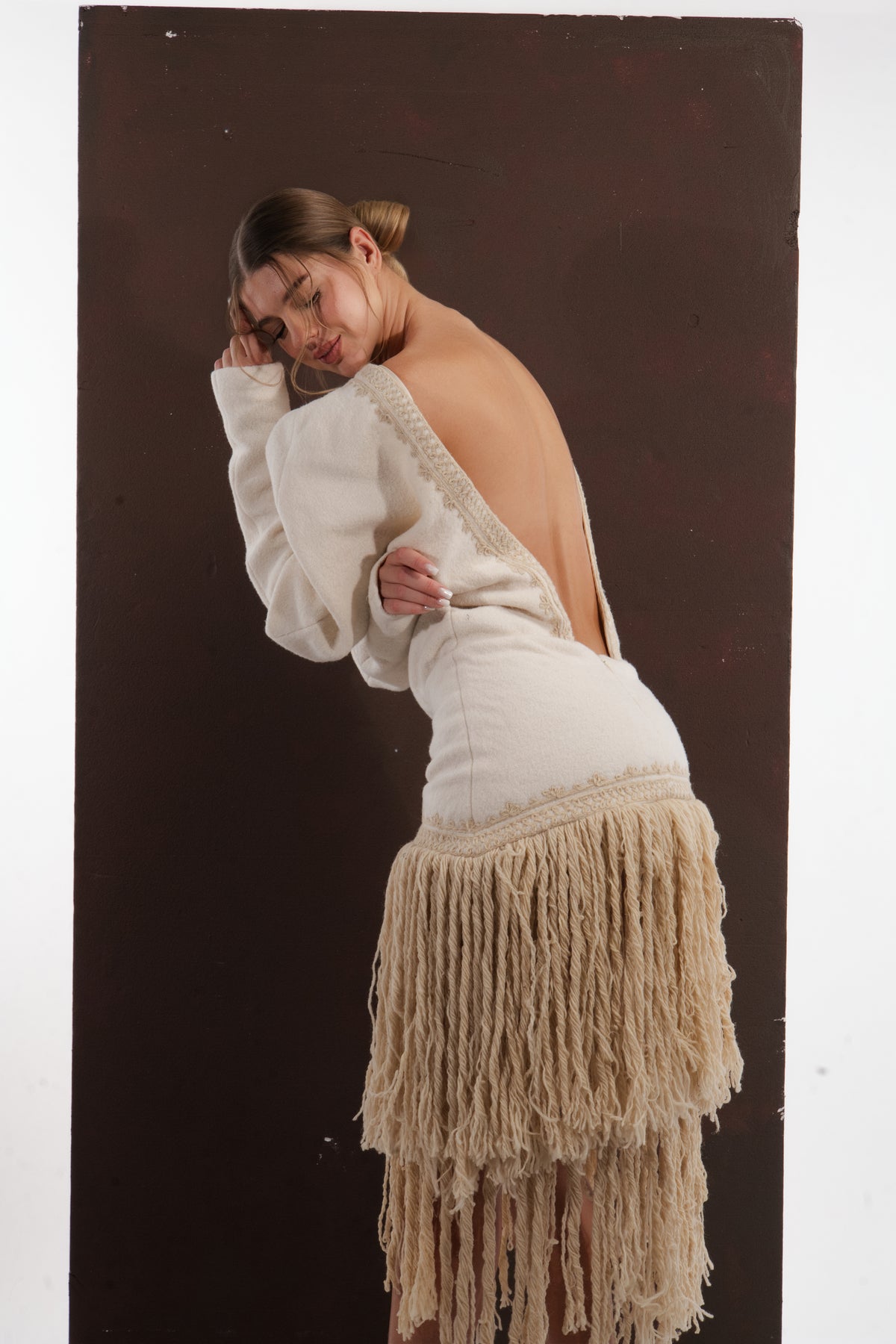 ALISADUDAJ ivory wool fringed dress, back view leaning forward showing open back and fitted hip