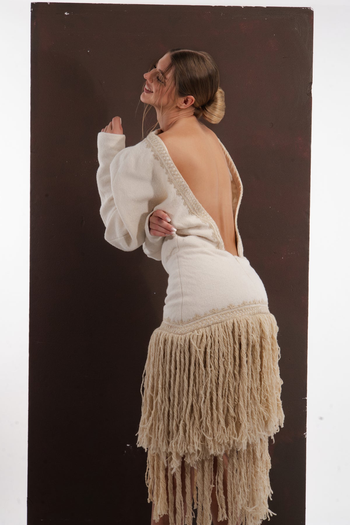 ALISADUDAJ ivory wool fringed dress, back three-quarter view showing open back and braid-trimmed edge