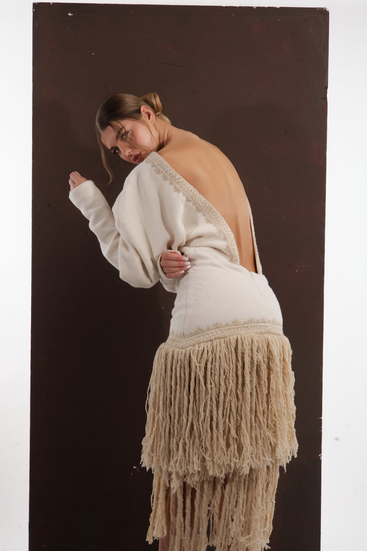 ALISADUDAJ ivory wool fringed dress, side back view showing fitted skirt and beige fringe tiers