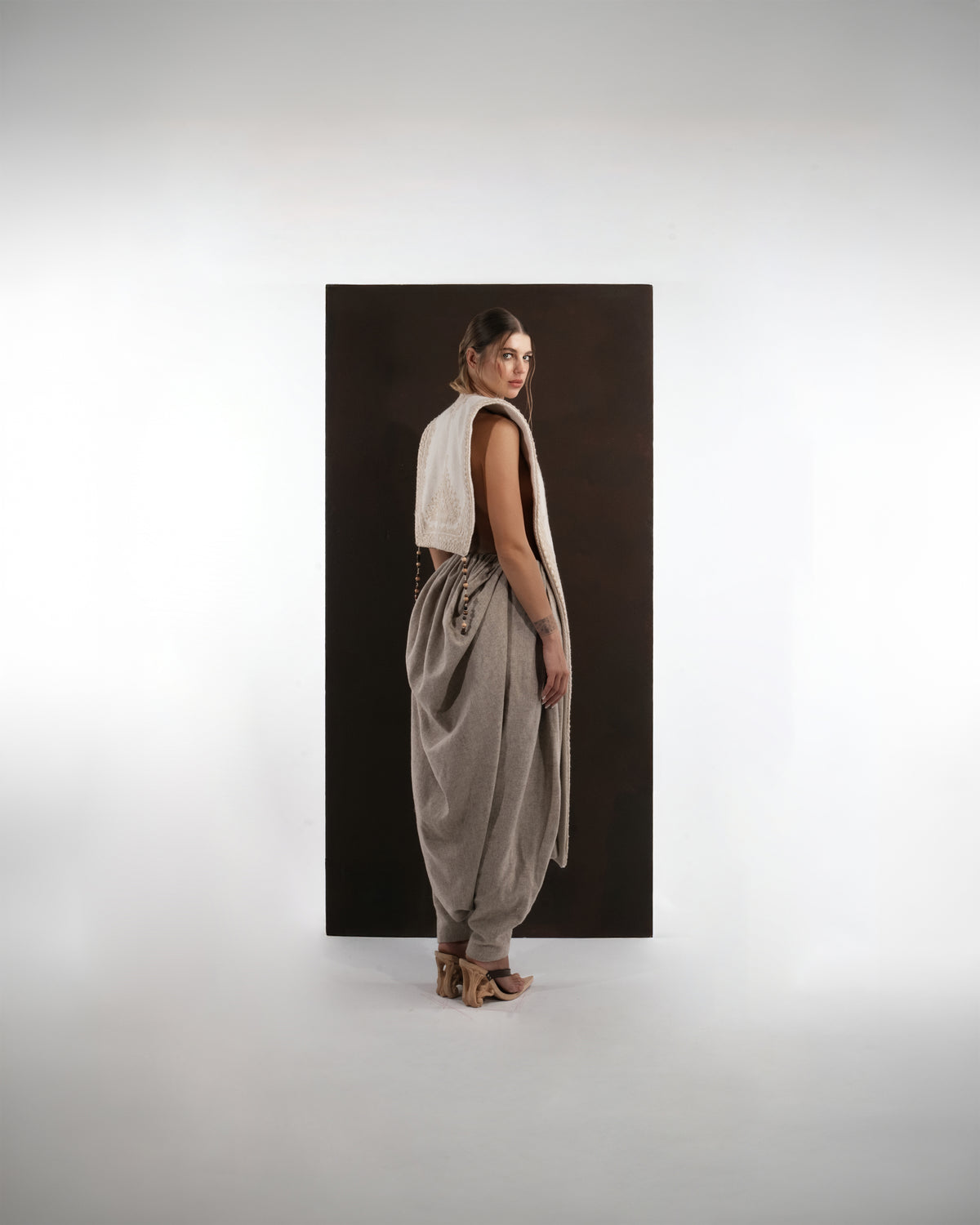 ALISADUDAJ ivory and grey wool beaded hooded vest and draped trouser set, back three-quarter view looking over shoulder