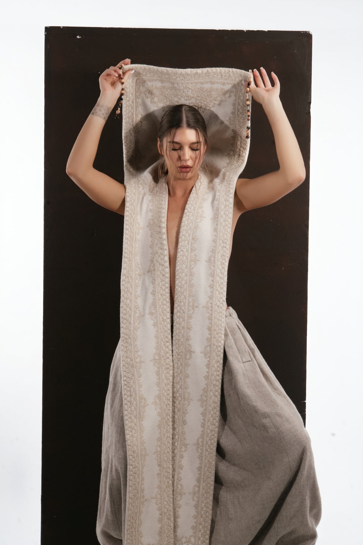 ALISADUDAJ ivory wool beaded hooded vest, front close-up with hood spread wide overhead showing patterned lining