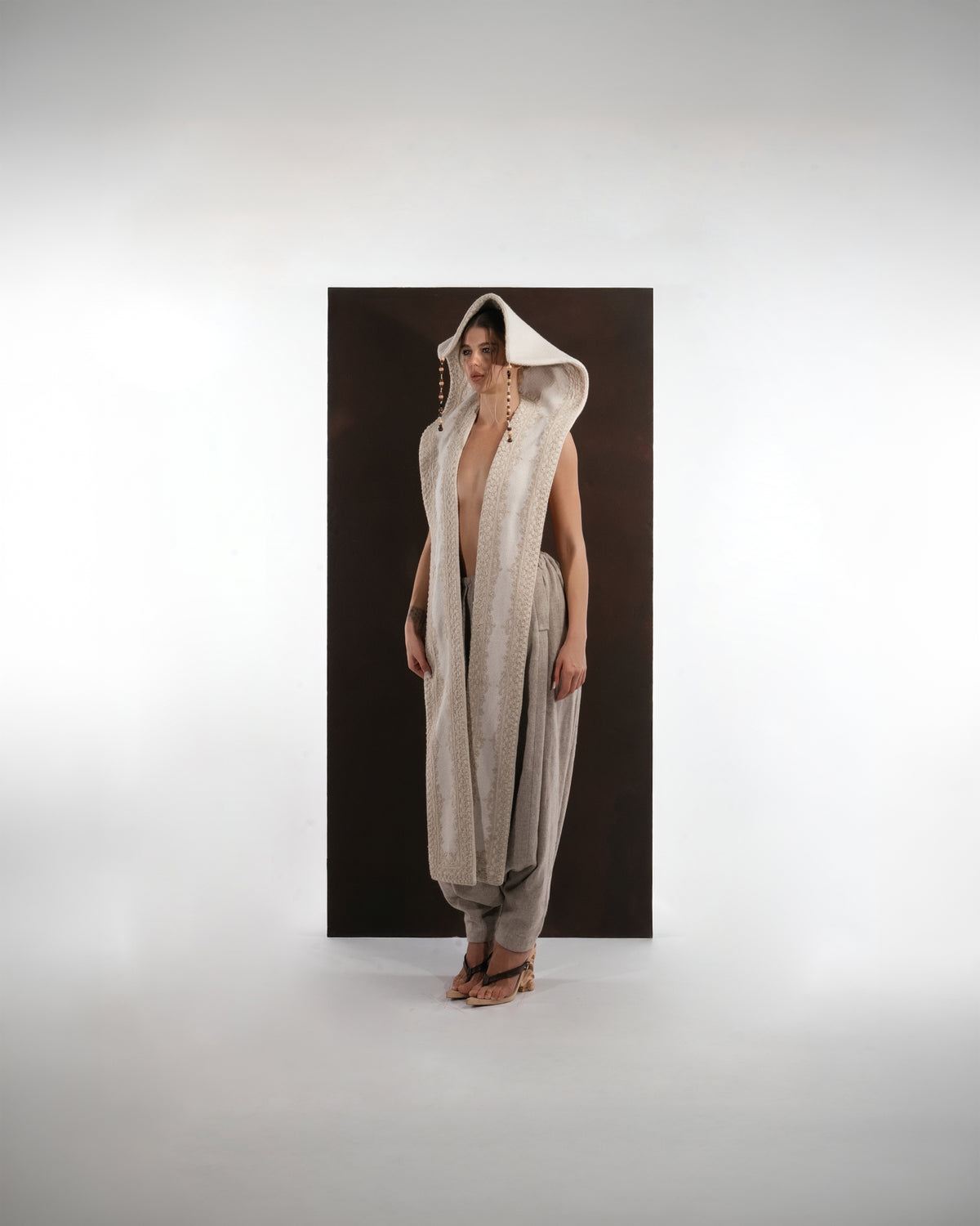 ALISADUDAJ ivory and grey wool beaded hooded vest and draped trouser set, front view with hood up and beaded cords