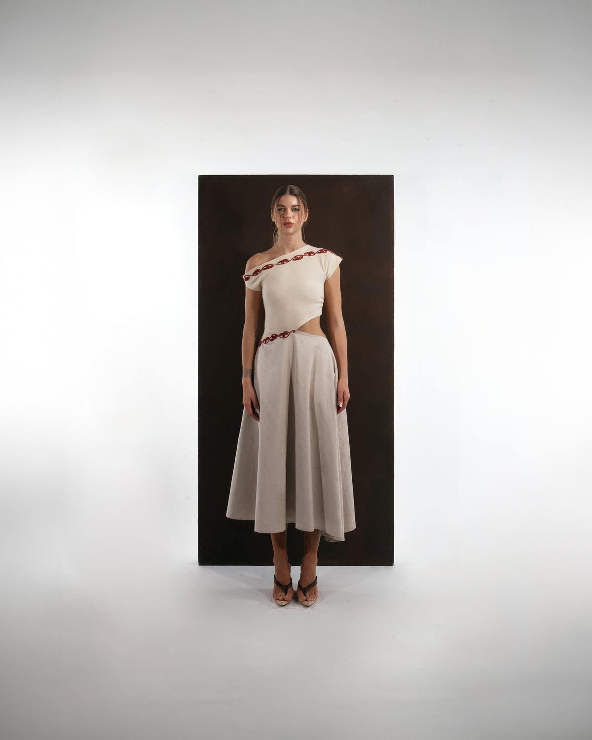 ALISADUDAJ ivory and grey wool dress with red embroidery, front view, full length, showing asymmetric neckline and waist cut-out