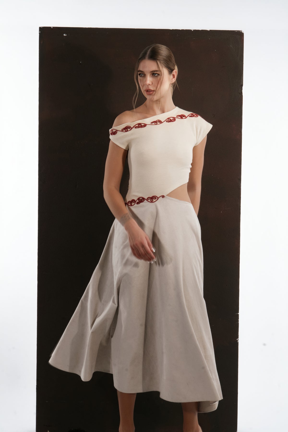 ALISADUDAJ ivory and grey wool red-embroidered dress, front view in movement showing flared grey skirt