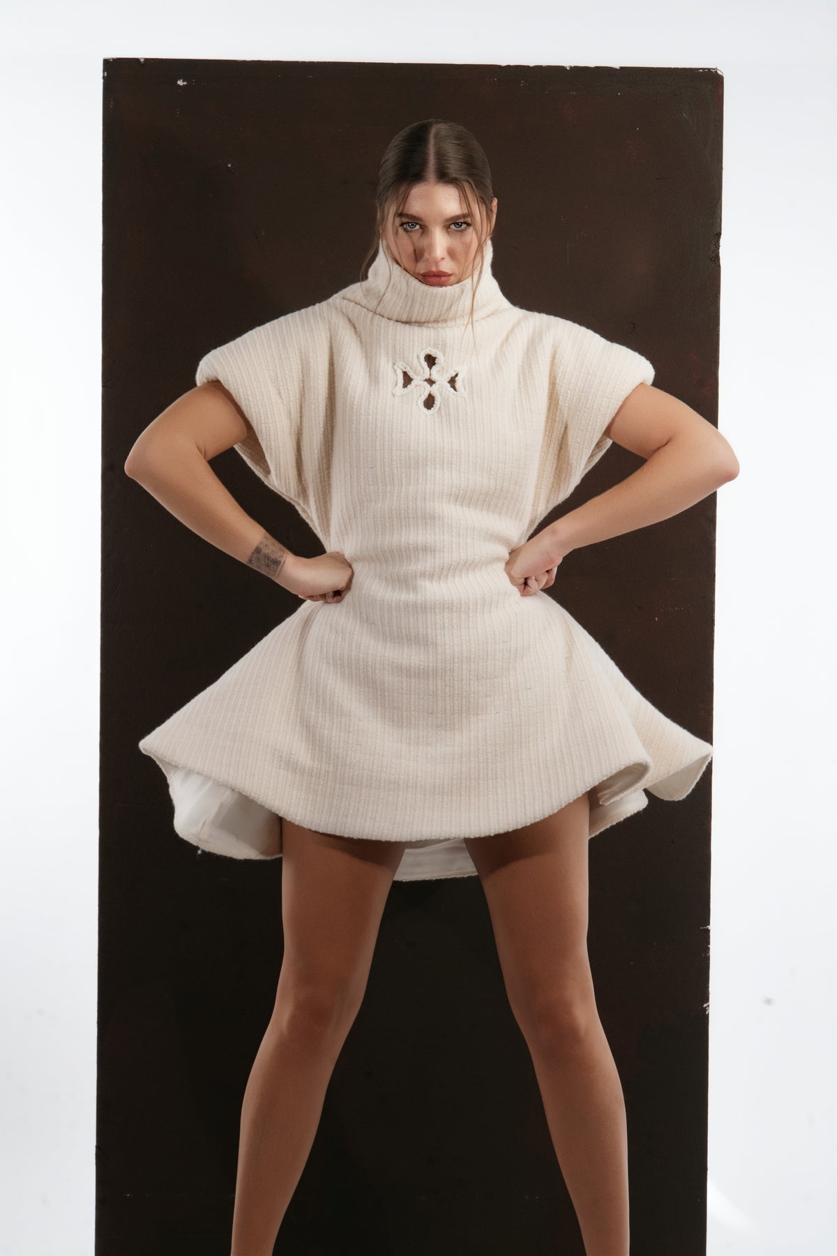 ALISADUDAJ ivory ribbed wool flared mini dress, front view with hands at the waist showing fitted bodice