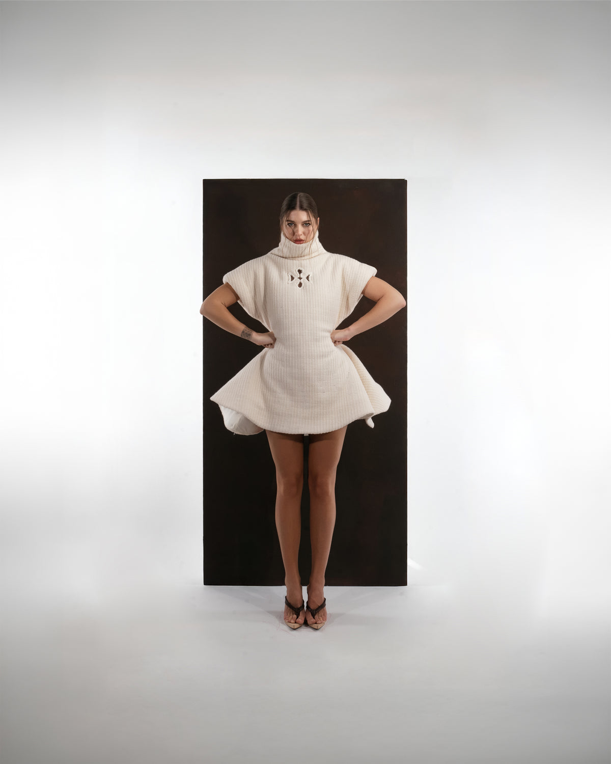 ALISADUDAJ ivory ribbed wool flared mini dress, front view with hands on hips showing structured cap sleeves