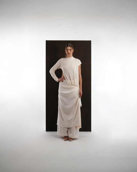 ALISADUDAJ ivory wool draped asymmetric set, front view with hand on hip showing one long sleeve and one cap sleeve
