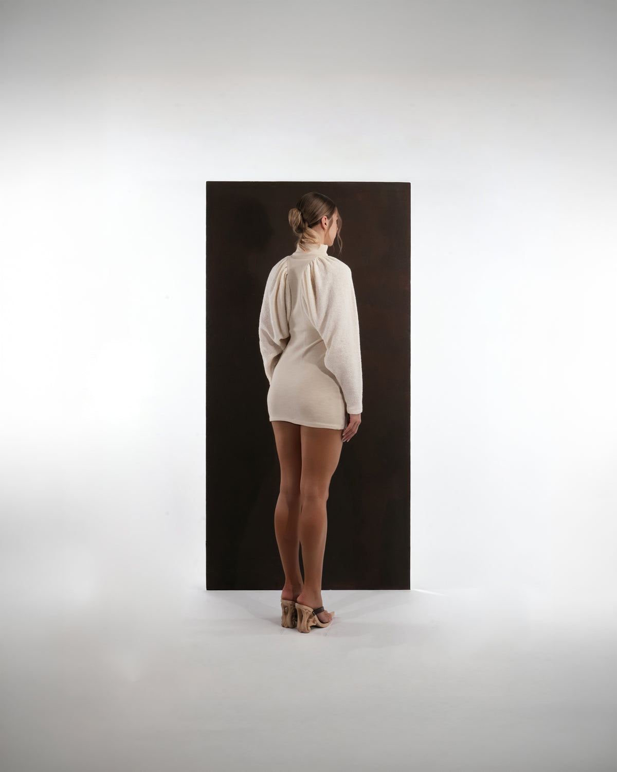 ALISADUDAJ ivory wool draped mini dress, back view showing fitted body and gathered raglan sleeves